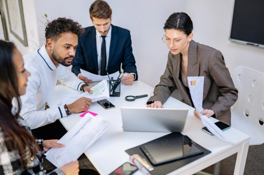 Professionals collaborating around a laptop